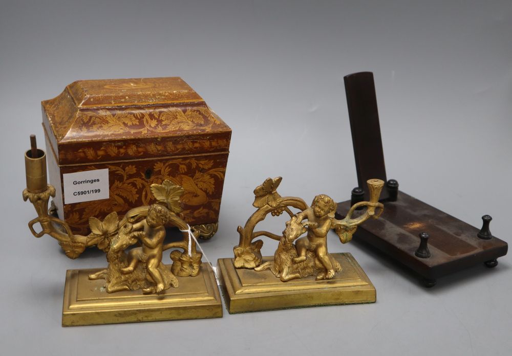 A William IV penwork tea caddy, a pair of ormolu Bacchanalian cherub candlesticks, lacking sconces and a hardwood dish stand